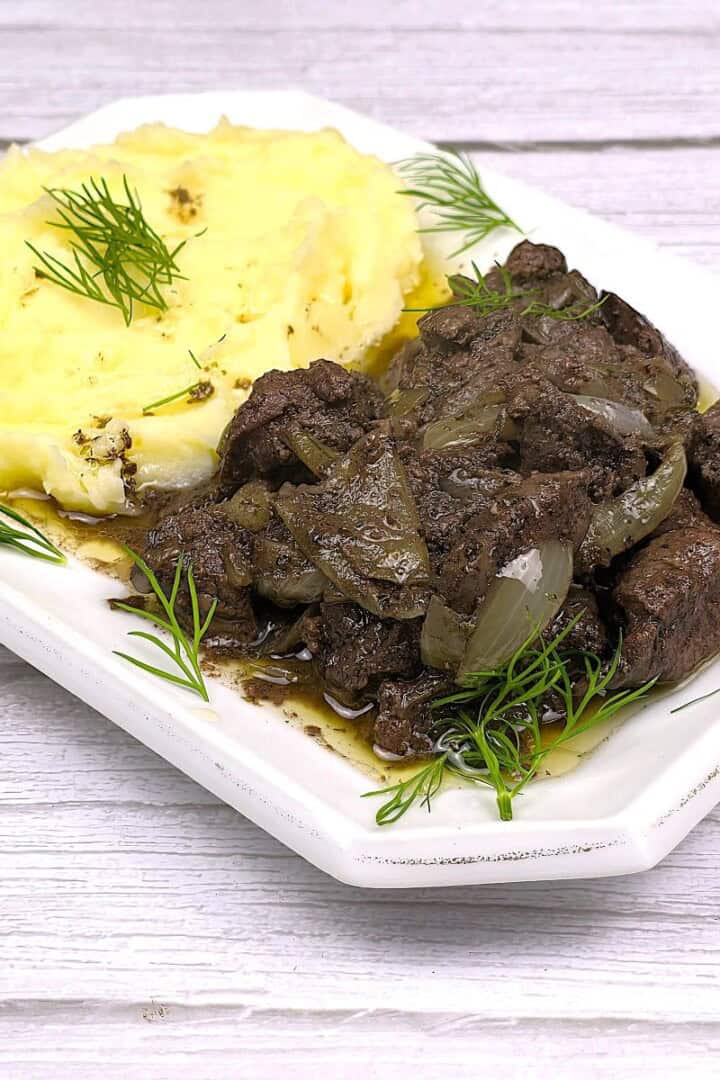 Chicken Livers With Onion Served on Square Plate With Mashed Potatoes
