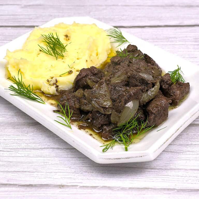 Chicken Livers With Onion Served on Square Plate With Mashed Potatoes