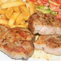 Pork steak with fries and vegetable salad