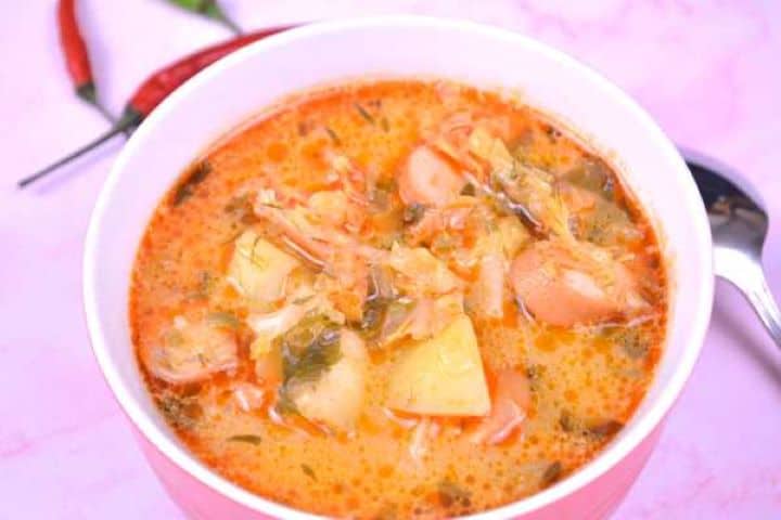 Serving Savoy Cabbage Soup with Frankfurters Served in Red Bowl With Chilly