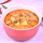 Savoy Cabbage Soup with Frankfurters Served in Red Bowl With Chilly Peppers