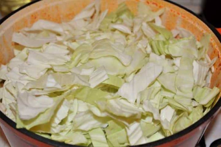 Cabbage Soup With Pork Meat-Add the Sliced Cabbage Over the Fried Pork Meat in the Pot Adding a mound of thinly sliced fresh white cabbage ribbons into the simmering pork soup.