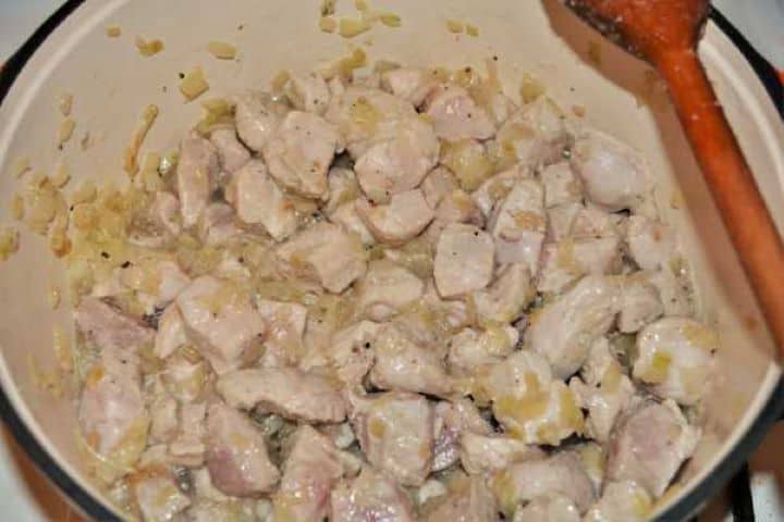 Cabbage Soup With Pork Meat-Fried Pork Meat in the Pot Searing pork shoulder cubes in a pot with onions until the meat turns white.