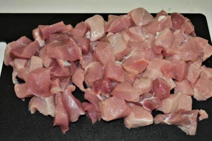 Cabbage Soup With Pork Meat-Pork Meat Cut in Cubes Diced raw pork shoulder cubes on a chopping board prepared for cooking.
