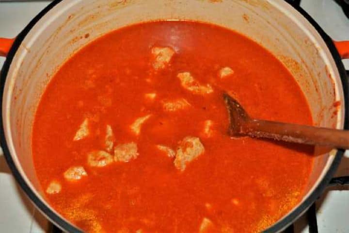 Cabbage Soup With Pork Meat-Pour Water Over the Fried Pork Meat in the Pot Pouring warm water over the seasoned Hungarian pork stew base in a soup pot.