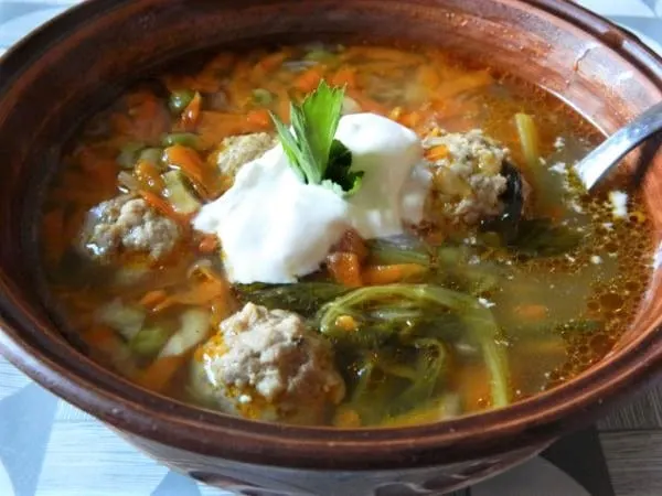 Pork meatballs vegetable soup, served with sour cream.