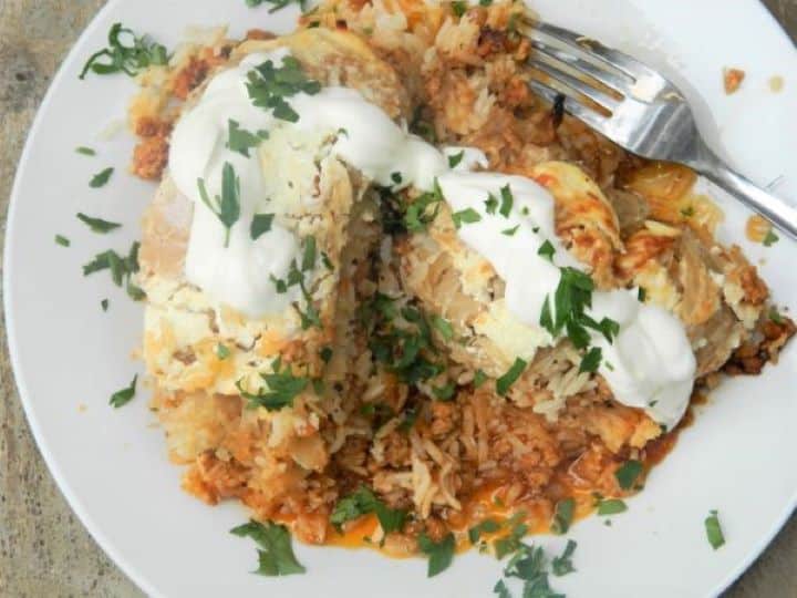 Cabbage Casserole Recipe-Served on Plate With Sour Cream on the Top Cabbage Casserole Served on White Plate