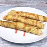 Three Cottage Cheese Filled Crepes Served on White Plate