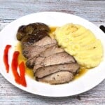 Oven-Roasted Turkey Thighs Served on Plate With Mashed Potatoes and Baked Apple