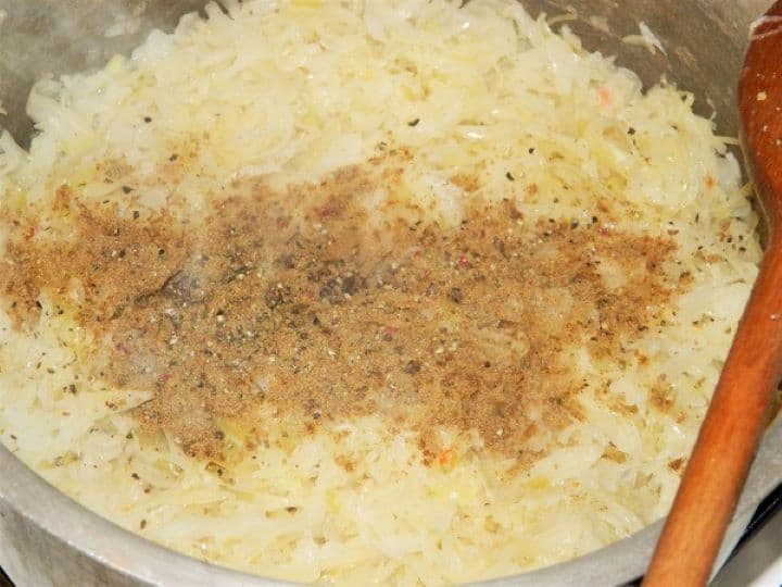 Seasoning sauerkraut with cumin and ground pepper Seasoning the sauerkraut and onion mixture with ground caraway powder and freshly ground black pepper.