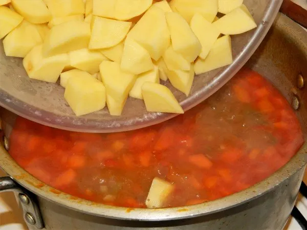 Traditional Hungarian Goulash Recipe-Adding Cut Potatoes to Boiling Goulash