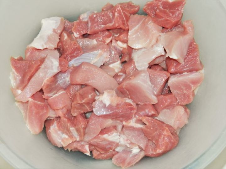 Raw pork shoulder cut into uniform, bite-sized cubes for slow braising.