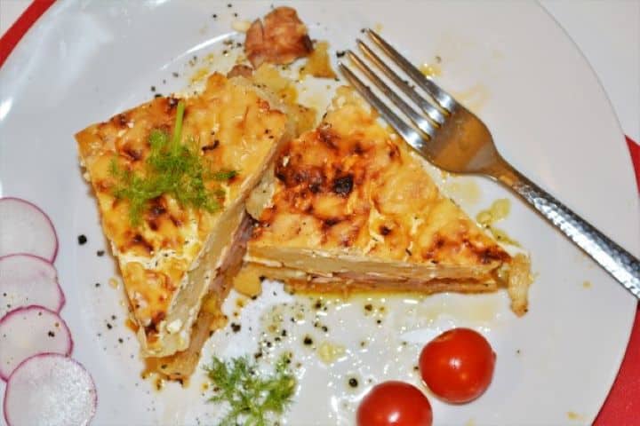 Best Cheesy Potato Casserole Recipe-Served on Plate With Cherry Tomatoes Hungarian Rakott Krumpli Served on Plate With Cherry Tomatoes and Radish