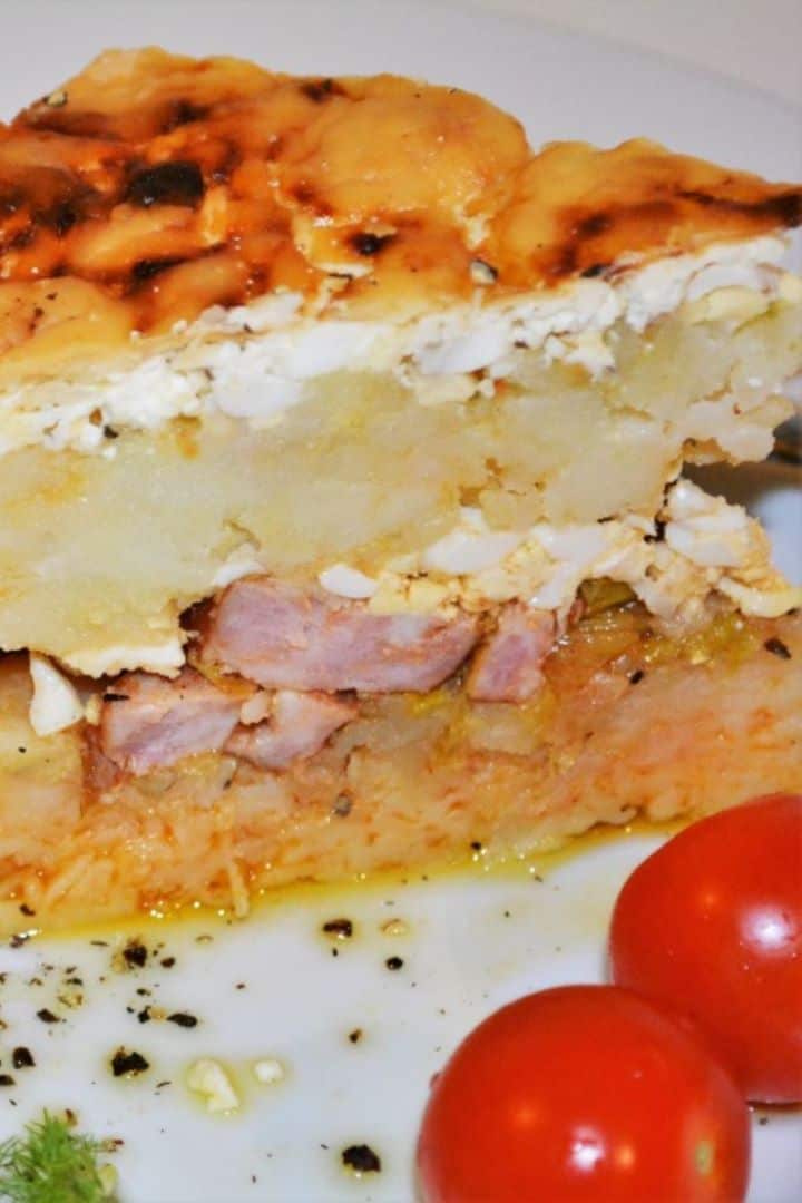 The best cheesy Hungarian Rakott Krumpli potato casserole with a golden cheddar cheese crust served on plate