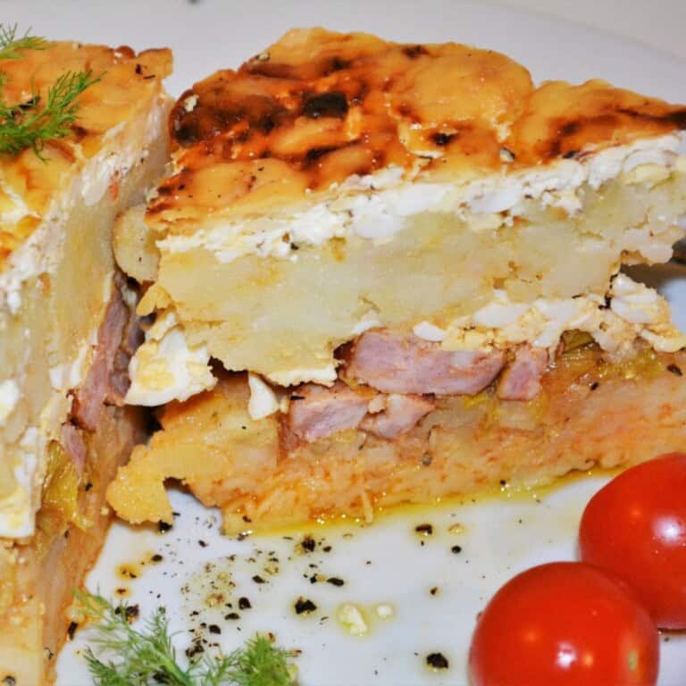 Cheesy Hungarian Rakott Krumpli Potato Casserole Served on Plate With Cherry Tomatoes