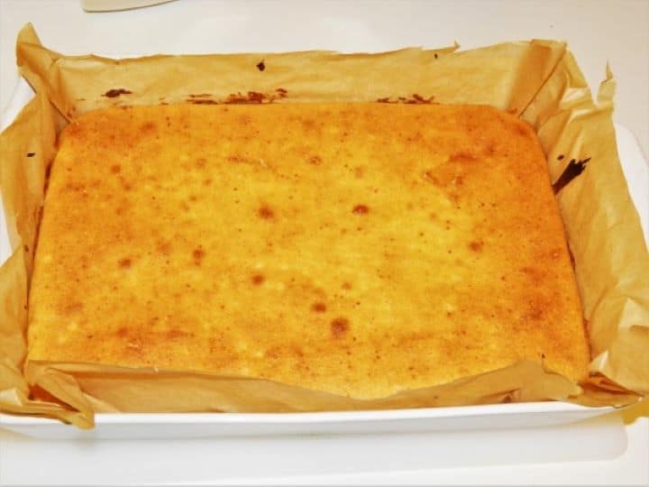 Freshly baked golden brown sweet cornbread in a rectangular baking tray.