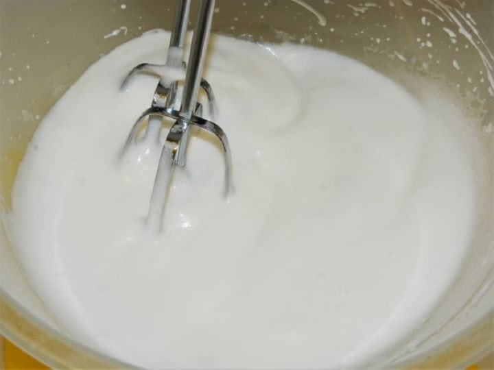 Whisking egg whites into a stiff foam.