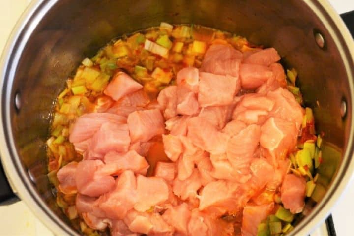Best Turkey Stew Recipe-Add Turkey Breast on Fried Leak Cubed turkey breast cooking low and slow under a tight lid, simmering in its own juices with leeks and red paprika gravy.