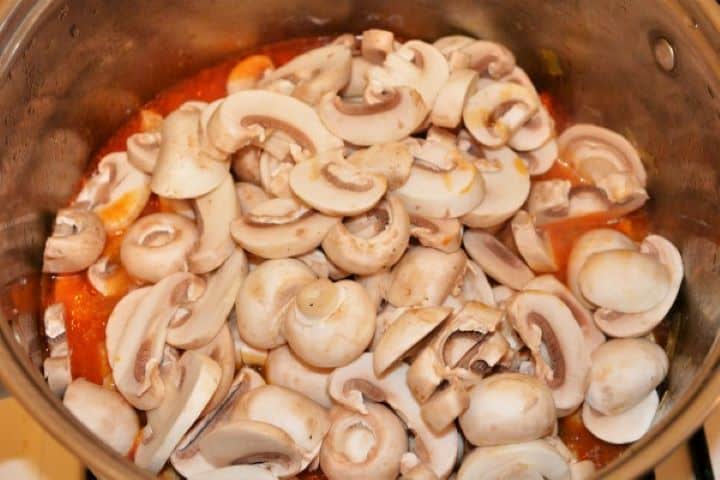 Best Turkey Stew Recipe-Put the Mushrooms in the Stew Freshly sliced white champignon mushrooms being stirred into a bubbling pot of authentic Hungarian turkey stew.