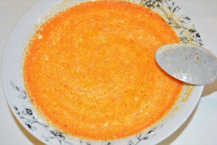 Best Turkey Stew Recipe-Stew Thickener With Stew Stock Pouring a ladle of hot broth into a bowl of single cream and wheat flour to temper the thickener for a creamy turkey stew.