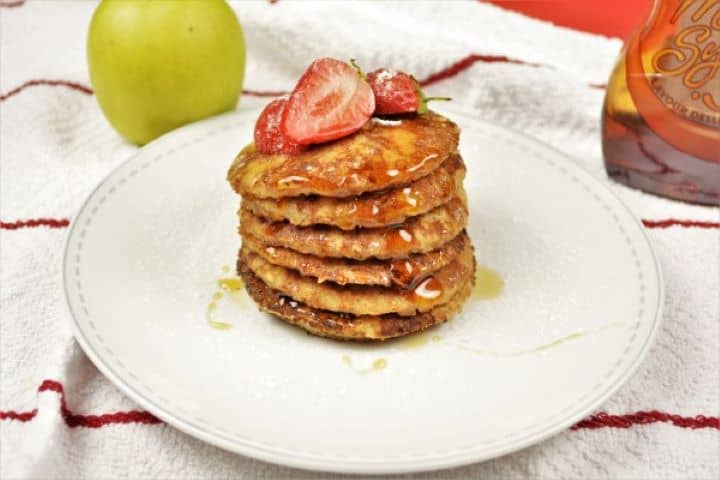 Easy Cinnamon Apple Pancakes Recipe-Served on Plate With Maple Syrup and Strawberry Easy Cinnamon Apple Pancakes Served on White Plate With Maple Syrup and Strawberries on Top