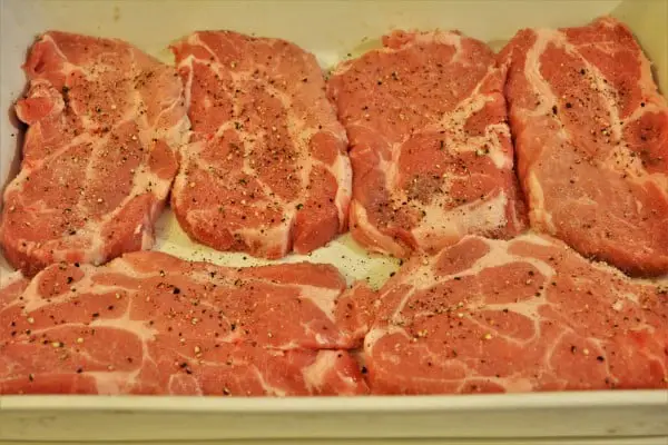 Easy Oven Baked Pork Steak Recipe-Sliced Pork Neck Seasoned With Salt and Pepper in the Tray