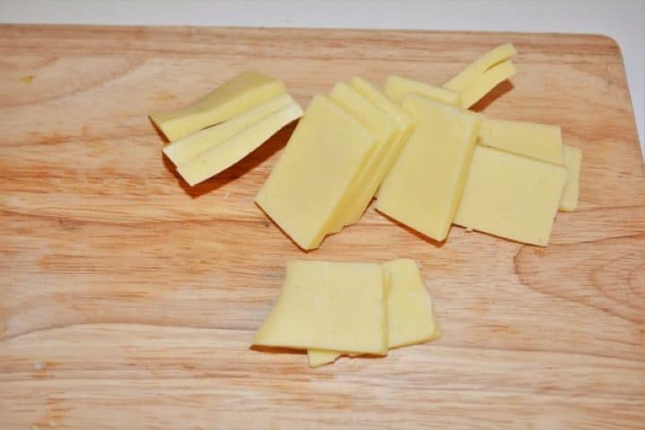 Sliced Cheddar Cheese on the Chopping Board