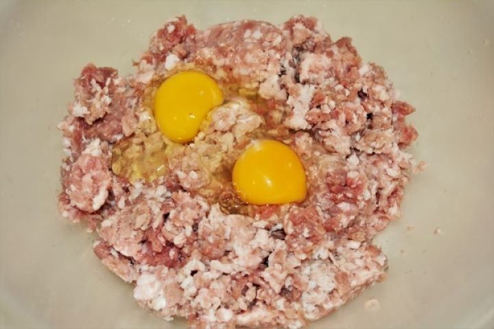 Two Whole Eggs on the Pork Mince in the Bowl