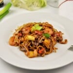 15-minute king prawn noodles recipe with teriyaki sauce and egg noodles on a white plate