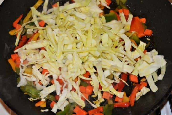 King Prawn Noodles Recipe - Sliced Sweetheart Cabbage on Frying Vegetables Stir frying peppers carrots and sweetheart cabbage in a large pan