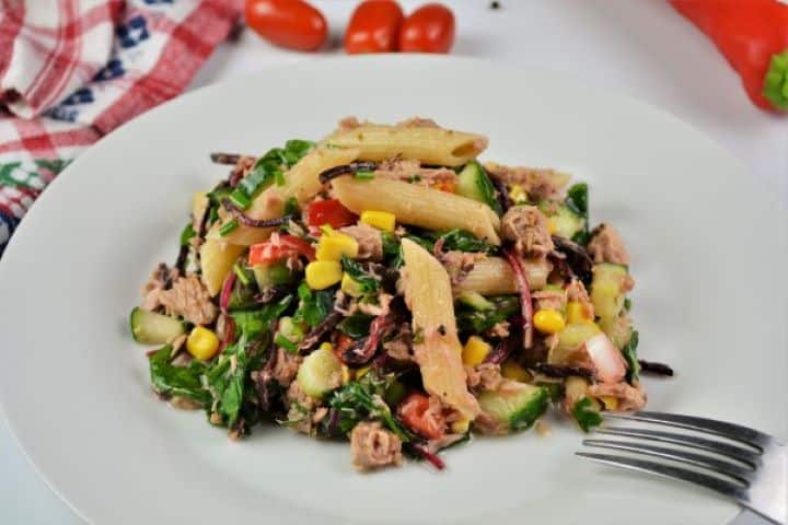 Simple Tuna And Pasta Salad Recipe - Served on Plate An individual serving of 15 minute tuna pasta salad served on a plate with fresh lemon wedges, ready for a light summer lunch.