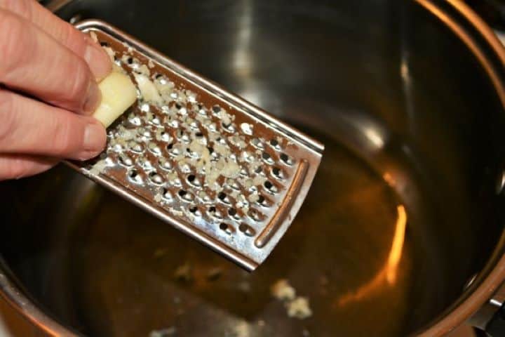 Easy Homemade Refried Beans Recipe-Grated Garlic in the Pot Grated fresh garlic cloves sizzling in sunflower oil in a large saucepan.