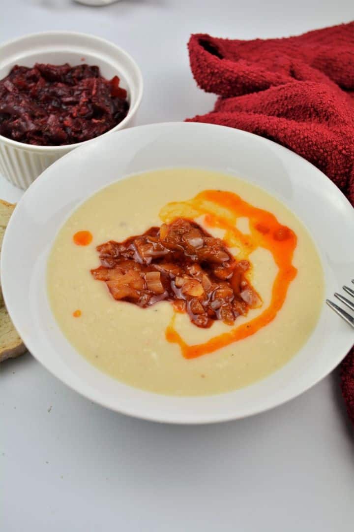 Easy Homemade Refried Beans Recipe-Served With Fried Onions Authentic Transylvanian mashed beans topped with caramelized paprika onions on a white plate.