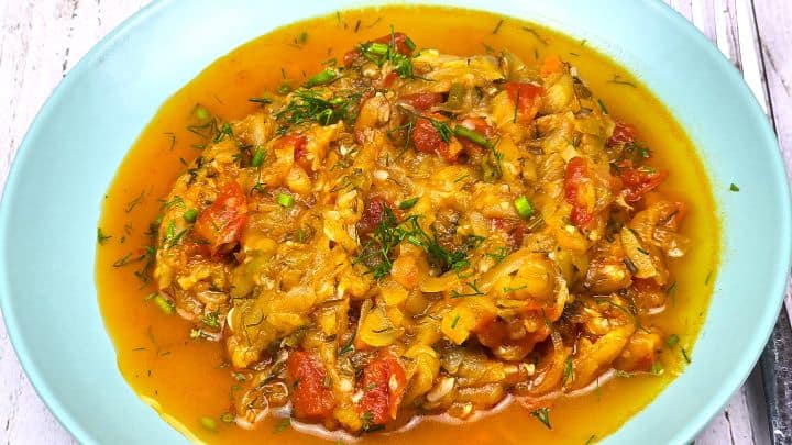 Grated Summer Squash Stew Recipe-Served on Plate With Soured Cream With Beaded Pork Chops Grated Summer Squash Stew Served on Blue Plate