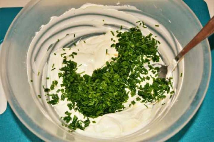 Best Smoked Salmon Cream Cheese Recipe-Chopped Chives on Cream Cheese in the Bowl Softened cream cheese and freshly chopped green chives being mixed together in a bowl.
