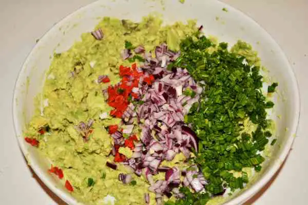 Best Homemade Guacamole Recipe-Chopped Chives, Red Onion and Chilli Pepper Over the Mashed Avocados