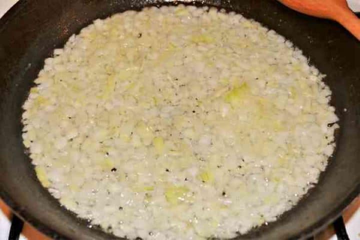 Easy Potato Moussaka Recipe-Frying Chopped Onions in the Pan Diced onions sautéing gently in sunflower oil in a skillet until translucent.