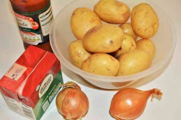 Easy Potato Moussaka Recipe-Potatoes, Onions and Tomato passata Ingredients for potato moussaka including whole potatoes, yellow onions, and rich tomato passata.