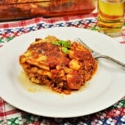 A square slice of baked potato moussaka showing layers of tender potatoes, minced pork, and a golden melted cheese crust.