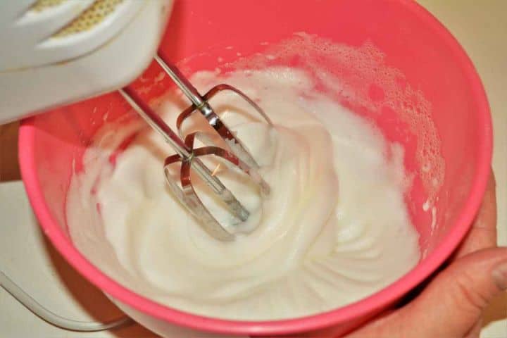 Best Cottage Cheese Dumplings-Making Egg White Foam With Electric Mixer in the Bowl Whipping egg whites with an electric hand mixer to soft peaks in a mixing bowl.