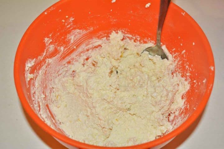 Best Cottage Cheese Dumplings-Mixed Cottage Cheese With Semolina, Flour, Egg Yolks and Lemon Zest Mixing dry curd cottage cheese, semolina, flour, egg yolks, and lemon zest in a glass bowl.