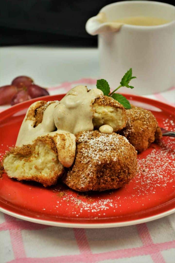 Best Cottage Cheese Dumplings-Served on Plate With Cream Fresh Authentic Hungarian cottage cheese dumplings (Túrógombóc) served on a red plate with sweet vanilla sour cream.