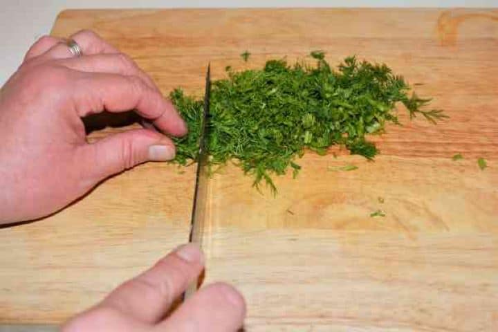 Turkey Cabbage Stew Recipe-Chopping the Dill Finely chopped fresh green dill on a chopping board.