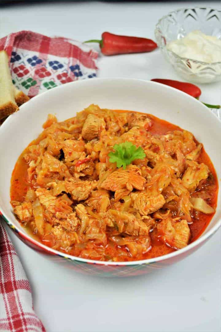 Turkey Cabbage Stew Recipe-Served in Bowl With Bread and Sour Cream Turkey cabbage stew recipe served in a bowl with sour cream, fresh dill, and hot chili peppers.