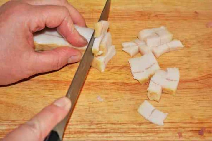 Brasov Roast Recipe-Cutting Pork Bacon Into Pieces 100g of finely diced smoked bacon ready to be rendered for the savory Brasov roast cooking base.