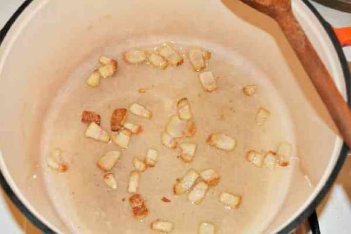 Brasov Roast Recipe-Fried Pork Bacon Pieces in the Pot Diced smoked bacon rendering its fat in a hot Dutch oven.