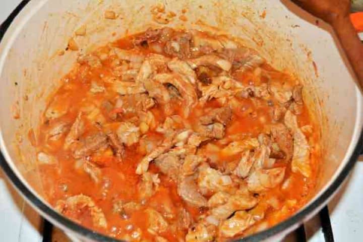 Brasov Roast Recipe-Pork Stew in the Pot Pork shoulder simmering and braising in a rich, dark red paprika and garlic gravy inside a Dutch oven.