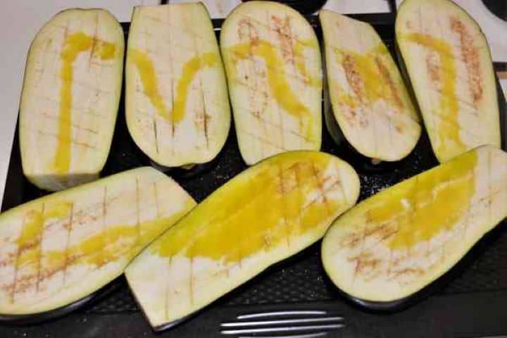 Stuffed Aubergines Recipe-Cut in Two and Notched Aubergines on Baking Pan, Salted and Sprinkled With Olive Oil Cut in Two and Notched Aubergines on Baking Pan, Salted and Sprinkled With Olive Oil