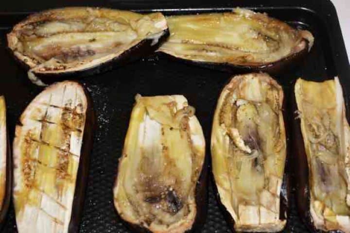Stuffed Aubergines Recipe-Scoop Out the Core of Baked Aubergines Using a spoon to gently scoop out the cooked core flesh from a baked eggplant half to form a sturdy aubergine boat.