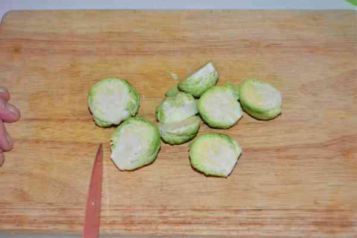 Brussels Sprouts With Lemon-Brussels Sprouts Cut in Two on the Chopping Board Trimmed Brussels sprouts cut in half lengthwise on a wooden chopping board.